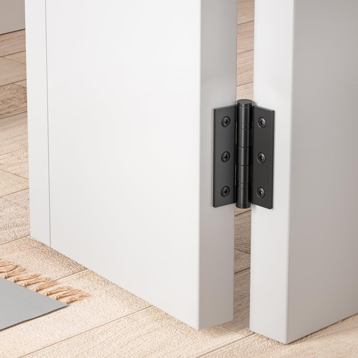 Black 3 inch door hinges installed on a wooden door