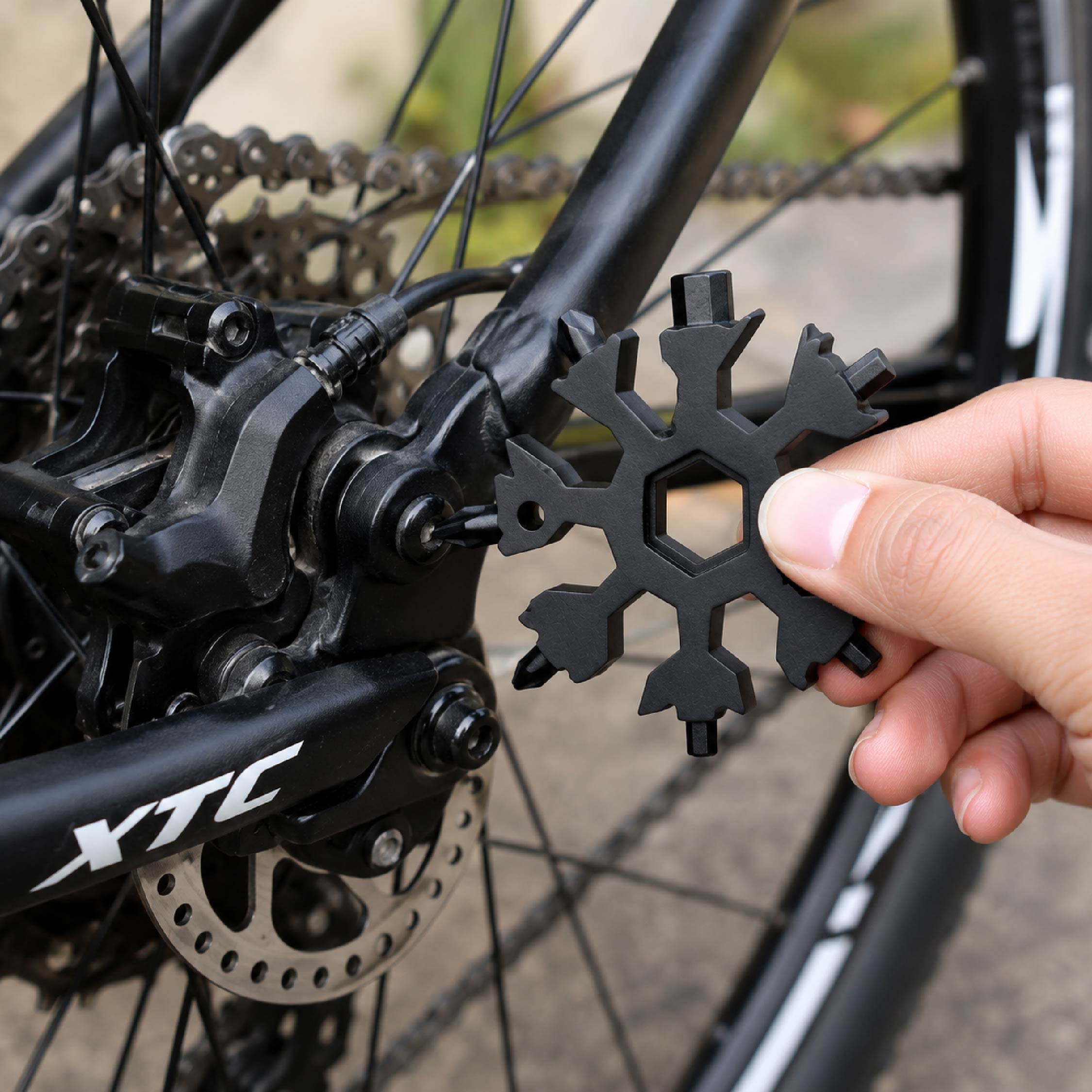 DOMIRA 18-in-1 Snowflake Multi Tool
being used to make quick bicycle
adjustments, demonstrating its
practicality for cycling maintenance and
outdoor adventures.