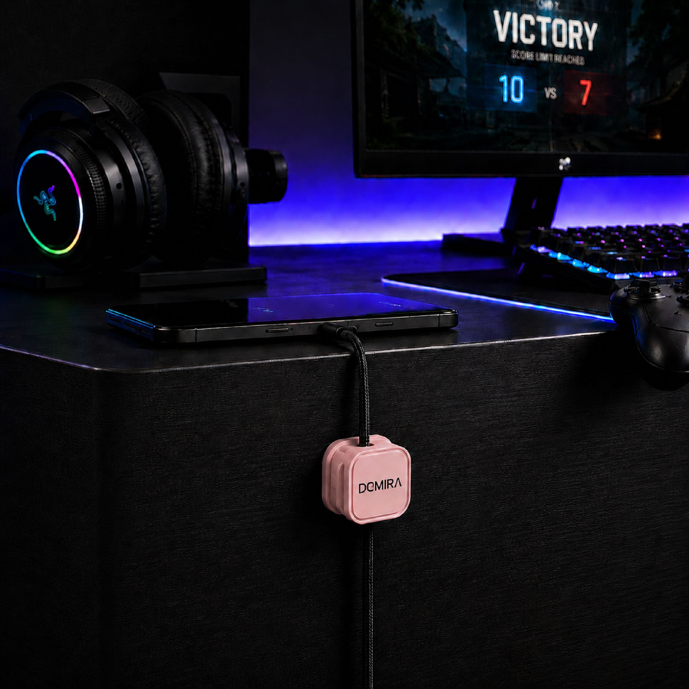 Pink magnetic cable clips used for desk
cable management beside a computer
setup to organise charging cables and
USB wires.