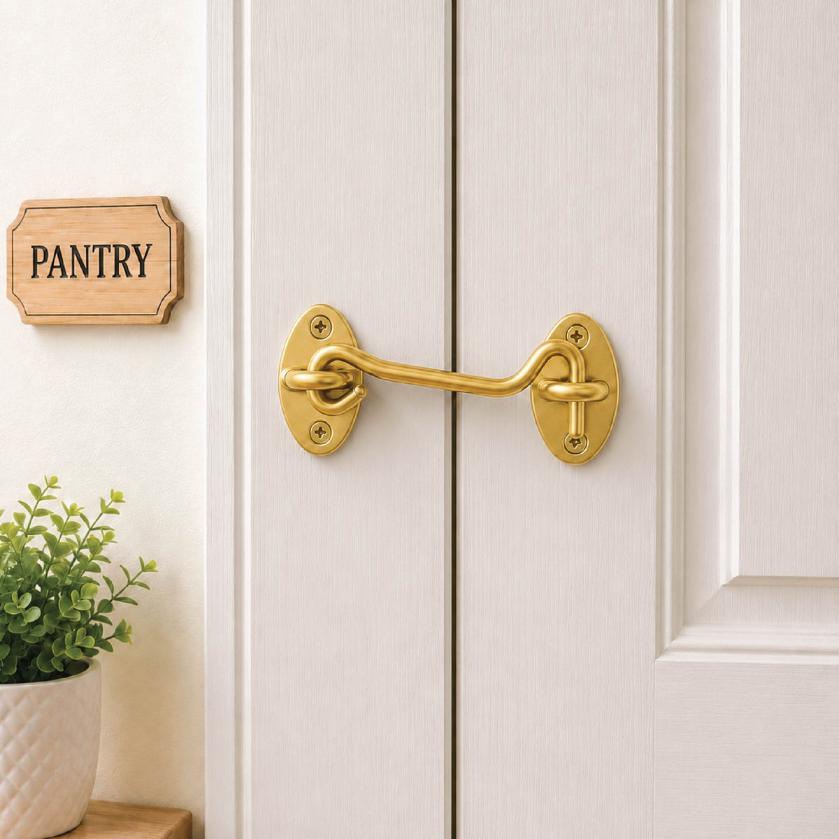 DOMIRA gold hook and eye door
latch shown securing a wooden door
for reliable closure