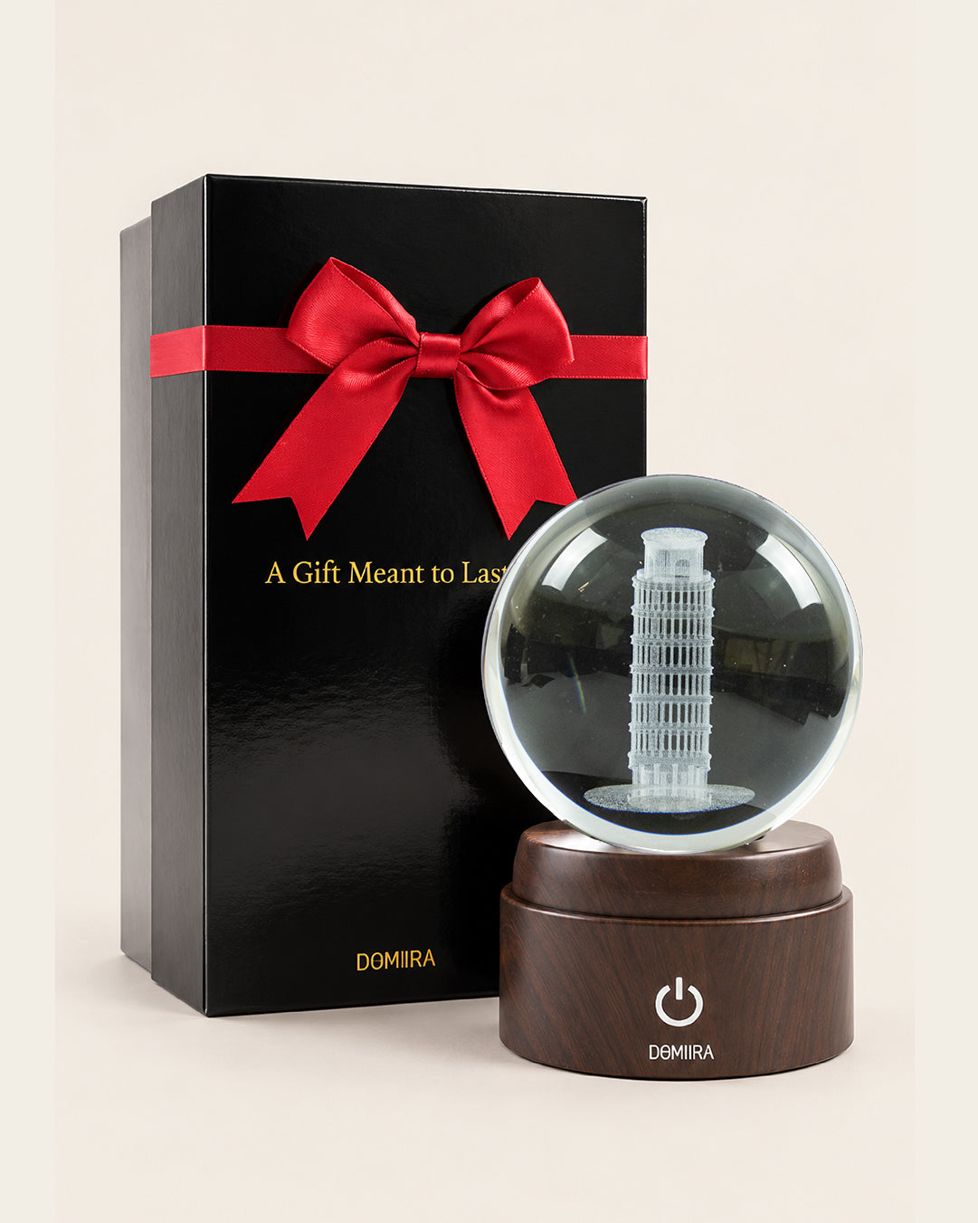 The Leaning Wonder crystal globe beside its ribbon-finished gift box