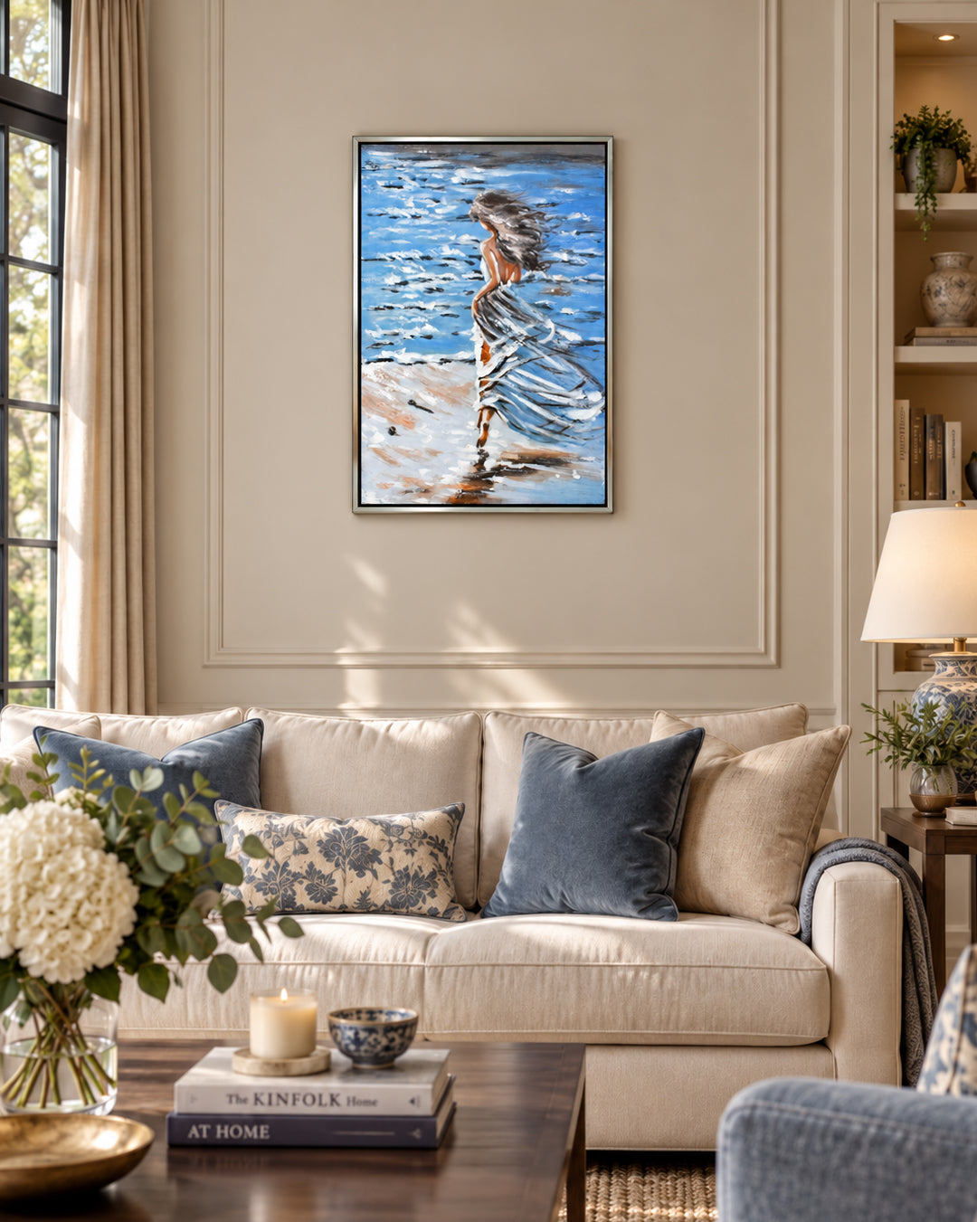 Untethered woman by the sea painting above a sofa in a living room